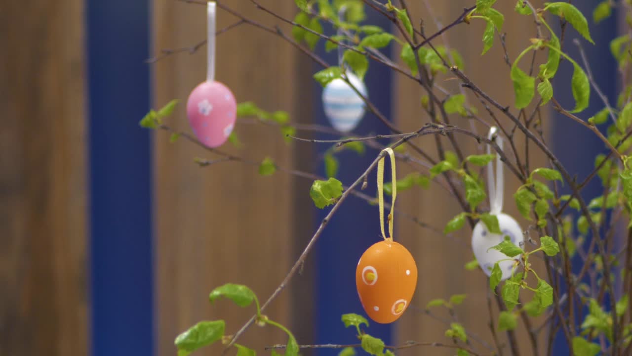 An artificial Easter egg hung on a birch branch in a vase