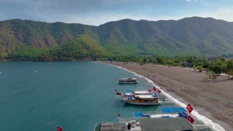 turkish coastline beach with boats and mountains