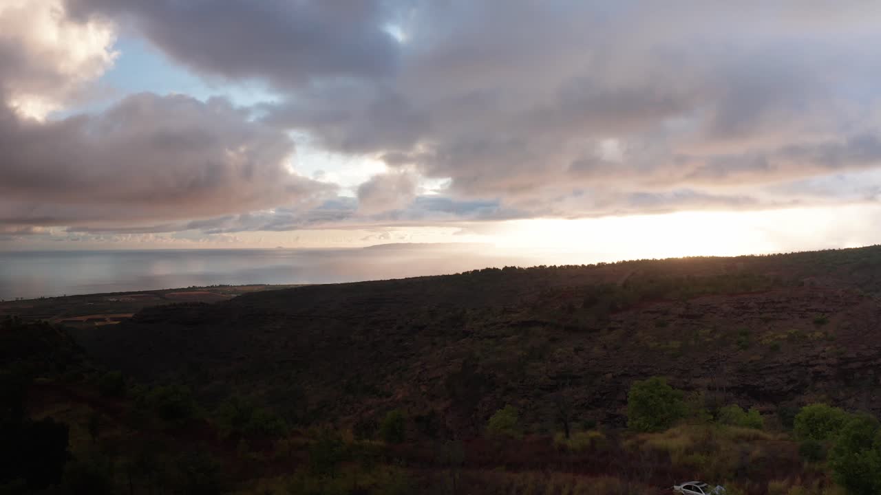 Aerial wide rising shot of the island of Ni'ihau from the southern coast of Kaua'i at sunset in Hawai'i