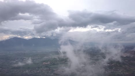 video from above. aerial view of a drone flying through some clouds. italian countryside on background.