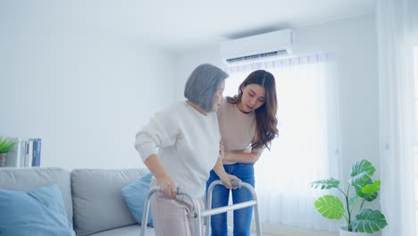 young woman assisting elderly woman with walker