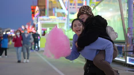 friends enjoying cotton candy at a night fair