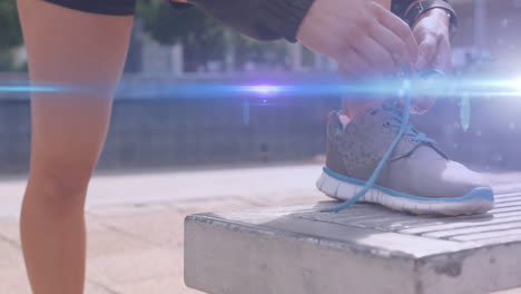 animación de luz azul moviéndose sobre los pies de una mujer en pantalones cortos atando un zapato para correr