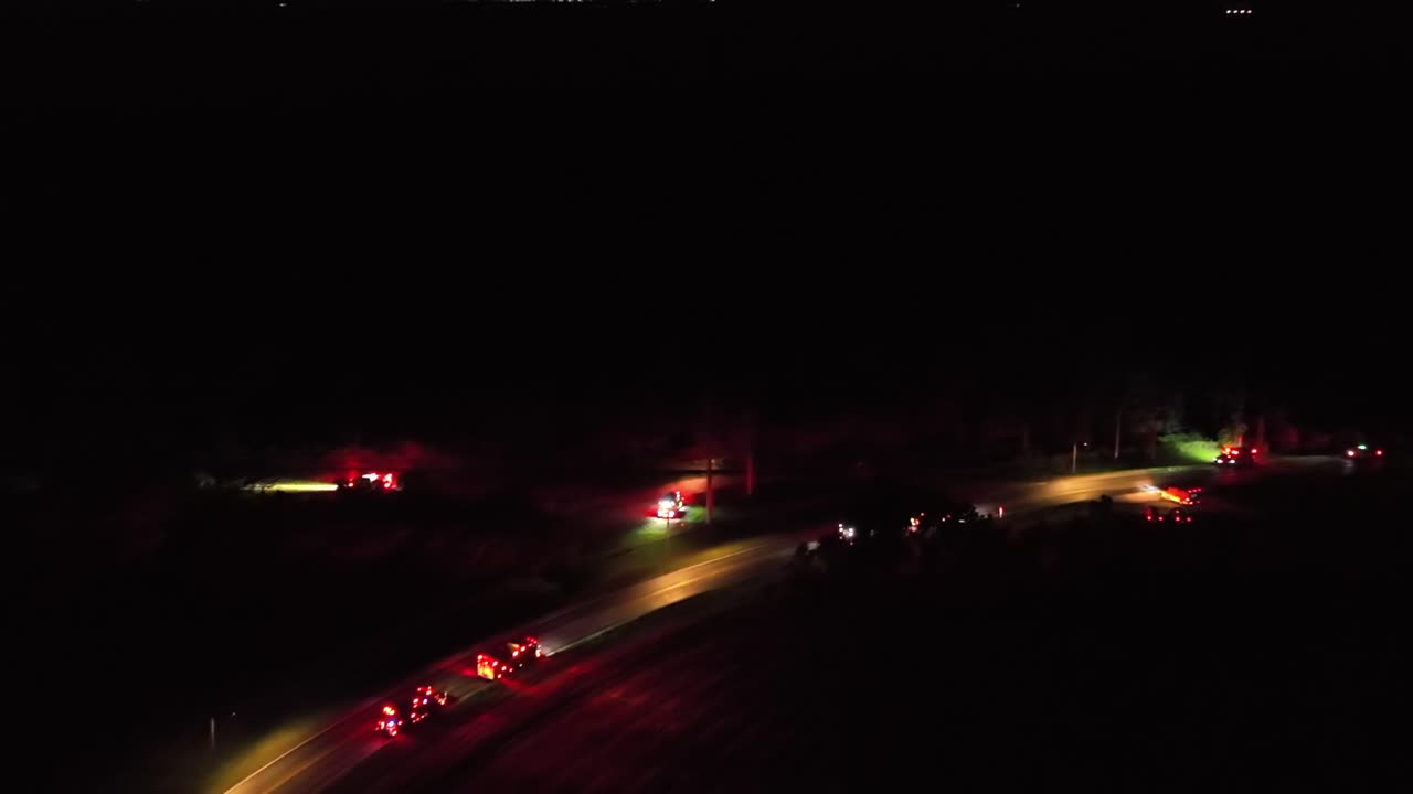Vehicle accident on highway road at night. Fire Truck, Police Car and Ambulance on street. American suburb district in Florida, usa. Aerial top down shot.