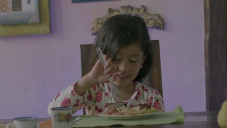 toma en cámara lenta de una niña riendo y riéndose mientras come