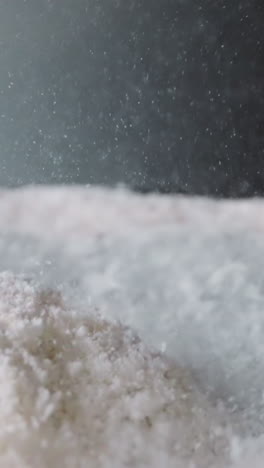 powdered sugar bounces from vibrations on surface with concavity. movement of white sweet powder. food product prepared for use at cooking macro