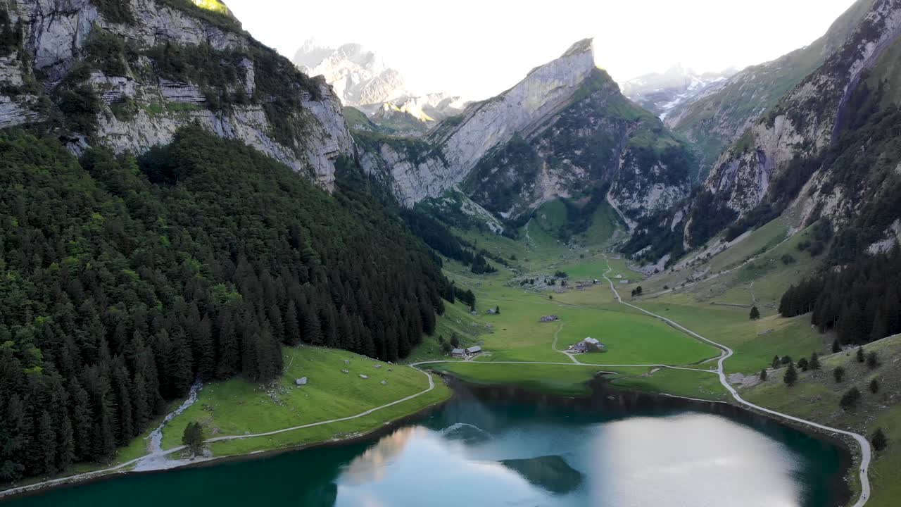 воздушный полет над озером зееальпзее в аппенцелле, швейцария, с отражением вершин альпштайна на поверхности озера