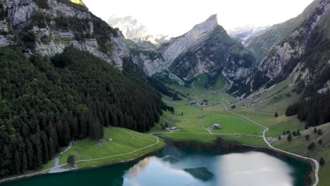 sobrevuelo aéreo sobre el lago seealpsee en appenzell, suiza, con un reflejo de los picos alpstein en la superficie del lago