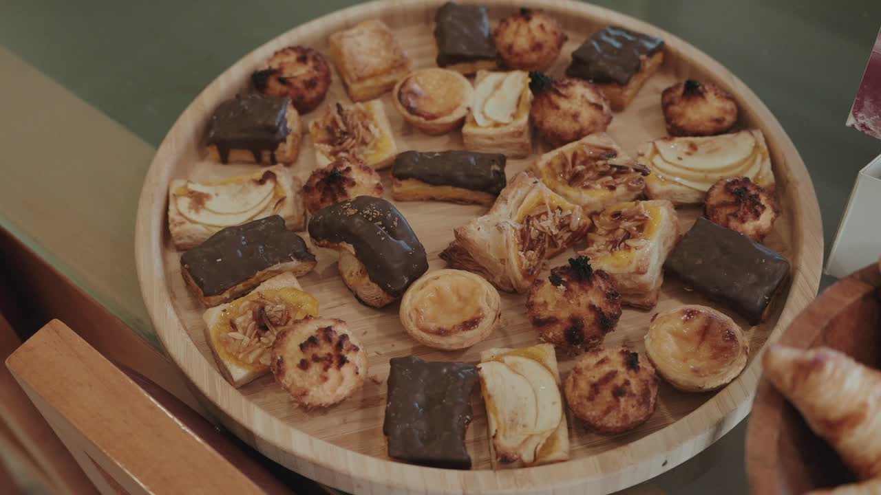 variety of bite sized pastries arranged neatly on wood plate