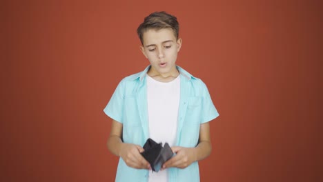 un chico sin dinero mirando su billetera vacía.
