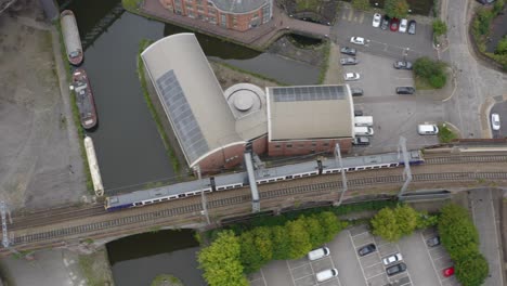 overhead drone shot tracking train travelling through castlefield canals 01