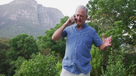 Senior-Caucasian-man-smiling-and-talking-on-the-phone-in-the-garden