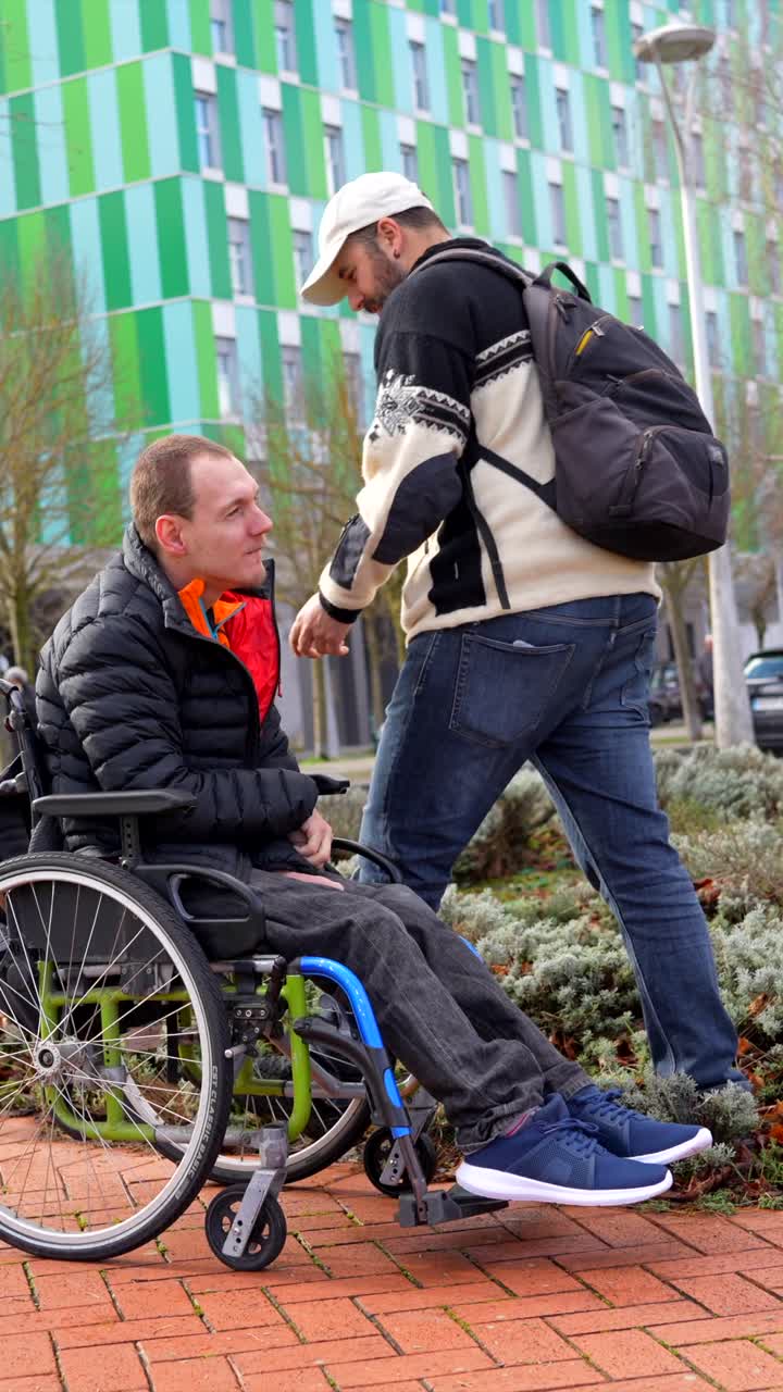 Man in Wheelchair Interacting with Friend Outdoors