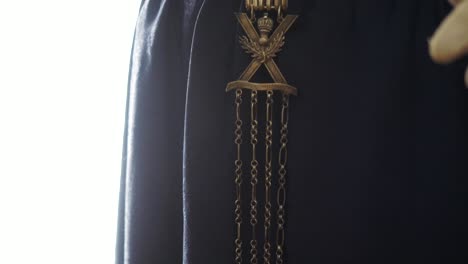 historical dress detail with medallion and chain