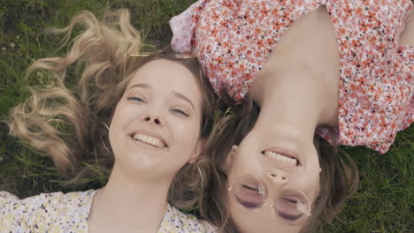 two friends laying on grass