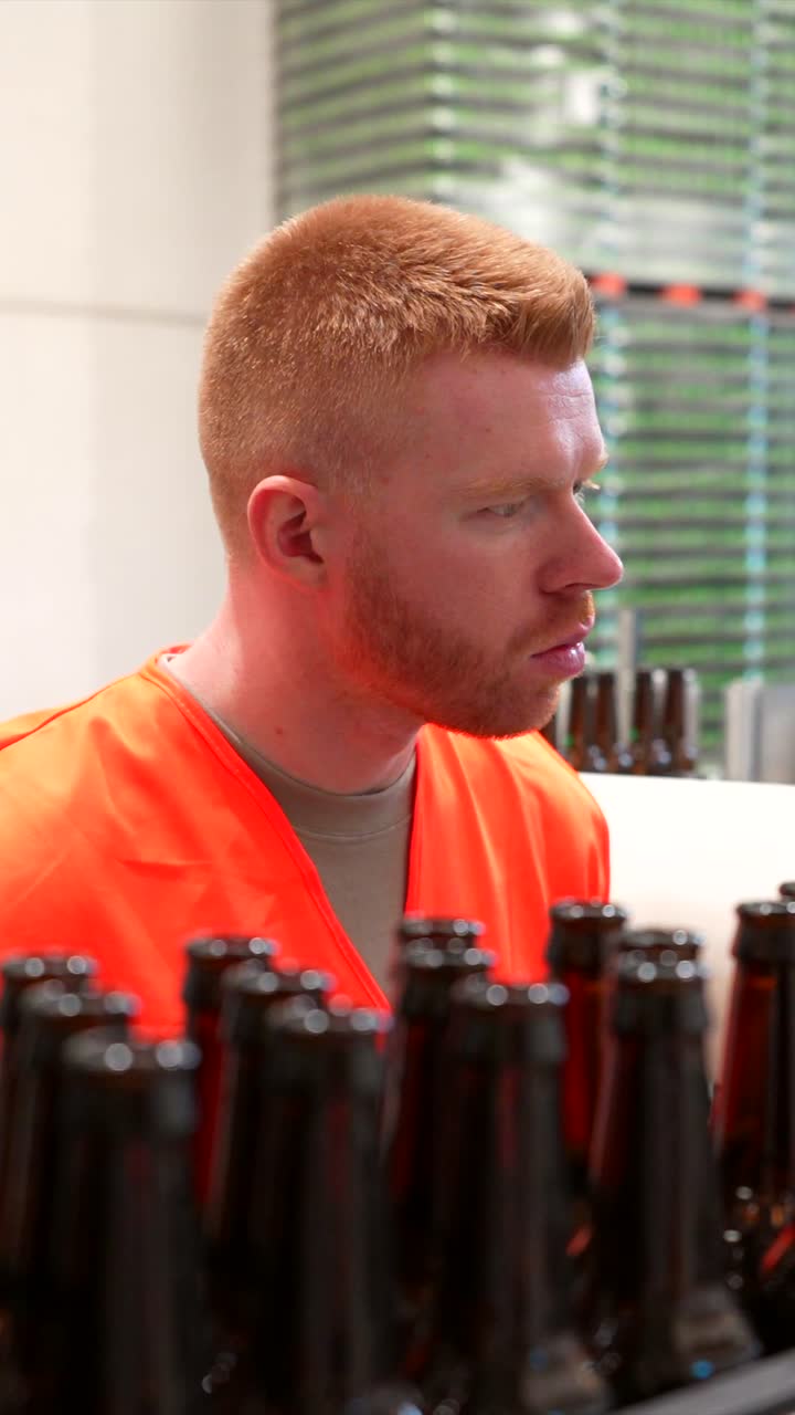 Factory worker inspecting beer bottles