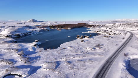 Isländische-Landstraße-Entlang-Des-Zugefrorenen-Sees-Mývatn,-Luftaufnahme