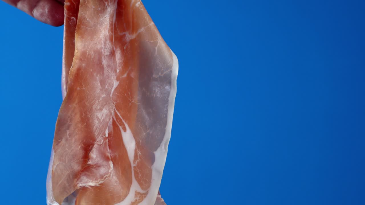 la mano del hombre sostiene un pedazo de antipasto.