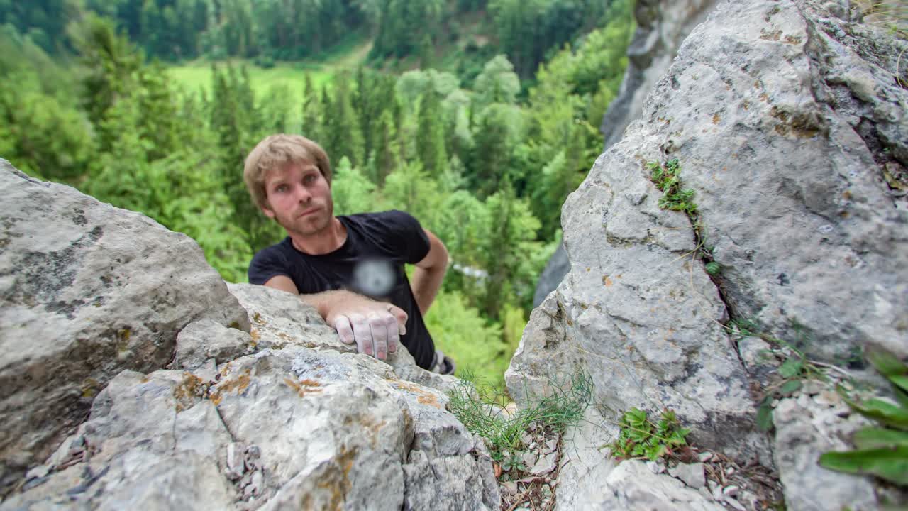 Climber man use hand to reach mountain summit Burjakove Peci, Slovenia