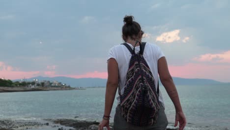 cámara lenta de mujer caucásica caminando en una playa en la isla agkistri, argosaronikos, grecia