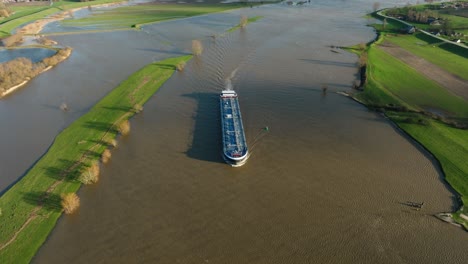 commercial shipping vessel transporting goods up flooded lek river