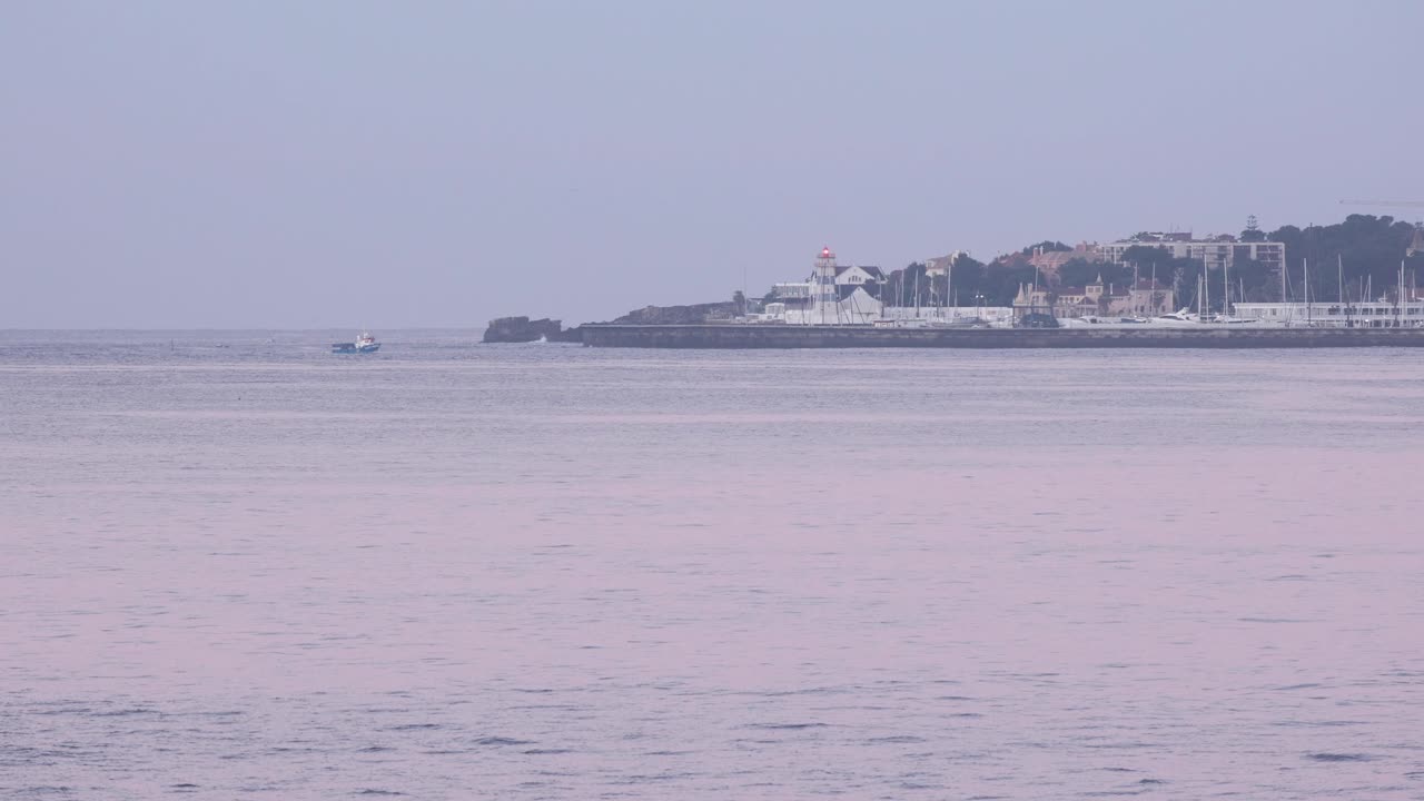 골든 아워 시간 에 포르투갈 의 카스카이스 해역 과 항구 로 돌아오는  ⁇ 시 배 의 광범위한 전망