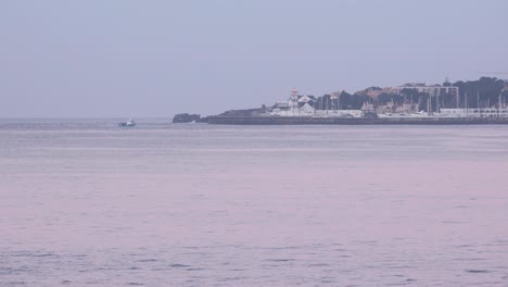 골든 아워 시간 에 포르투갈 의 카스카이스 해역 과 항구 로 돌아오는  ⁇ 시 배 의 광범위한 전망