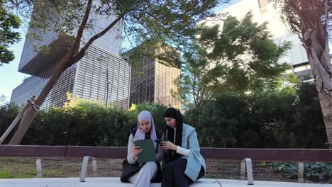 businesswomen with hijabs using technology outdoors