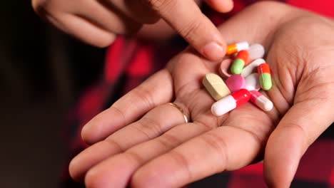 hand holding various pills