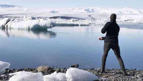 Joven-Viajero-Saltando-Piedras-En-La-Hermosa-Laguna-Glacial-En-Islandia-En-Cámara-Lenta