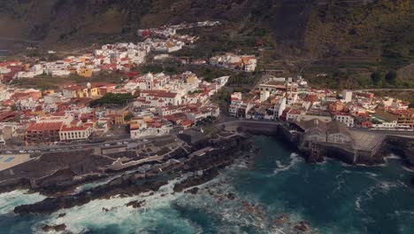 garachico fishing village in the canary islands, surrounded by its sea and guarded by its large catholic church, an aerial shot from a drone at 4k 60 fps - 02