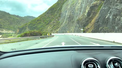 a car journey on great ocean road, showcasing coastal cliffs and winding roads under cloudy skies