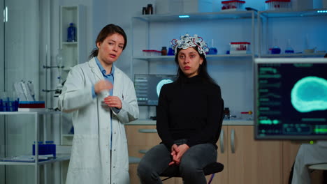 investigador y paciente con auriculares eeg mirando una pantalla virtual