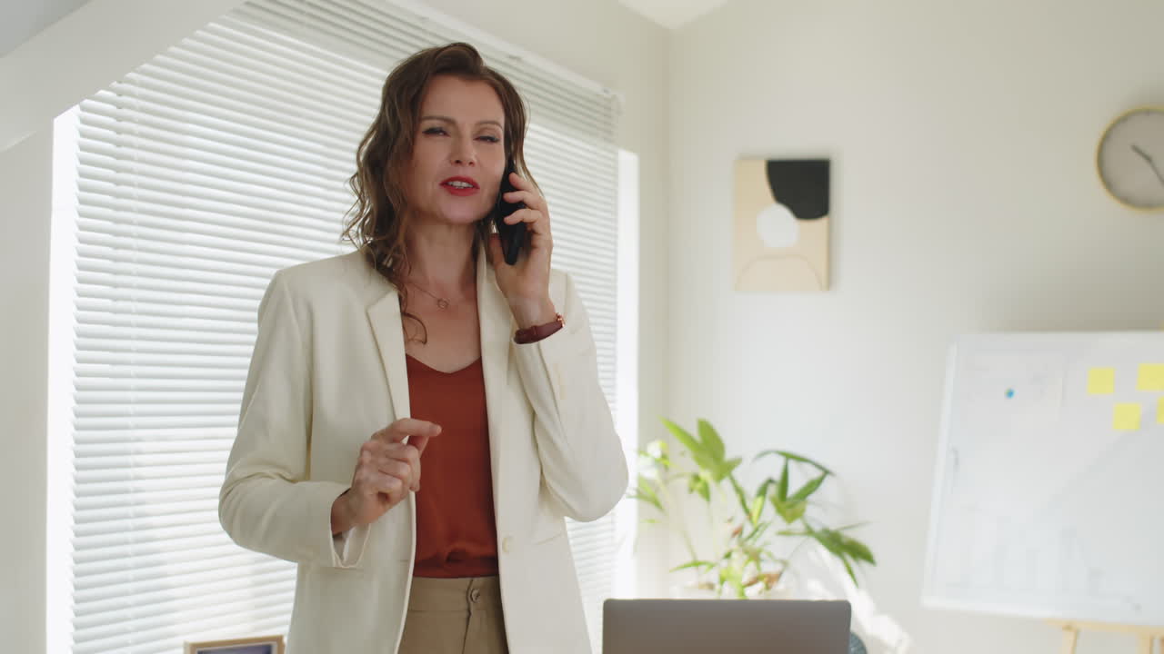 Confident Female Entrepreneur Discussing Work with Business Partner on Phone