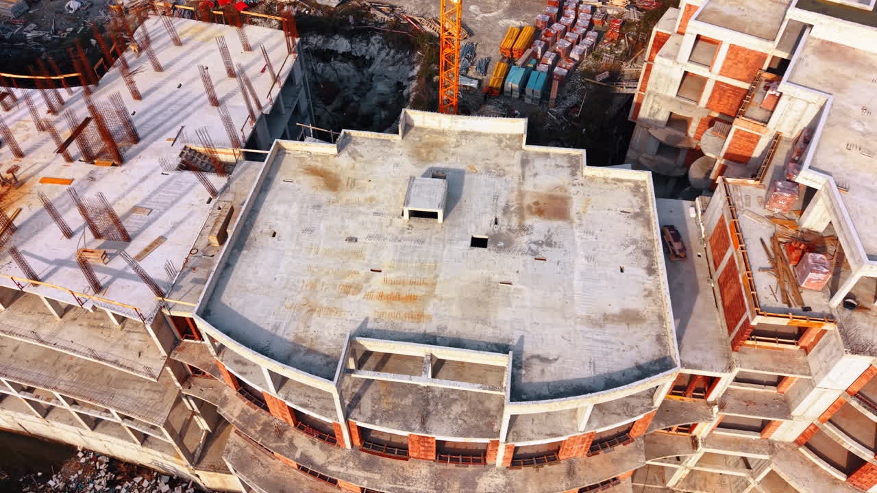 Building of a modern hotel. Drone footage over the roof of the building at the huge construction site