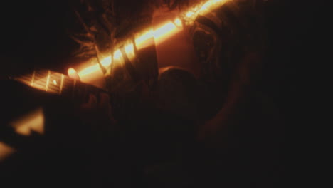close-up of man playing rock music on the guitar in dark room with light beam