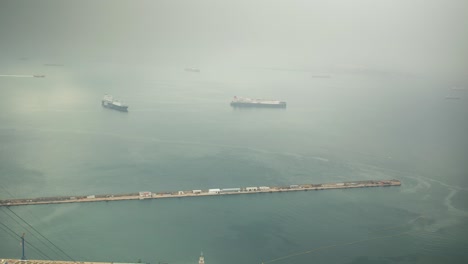 moored vessel near gibraltar harbor on thick foggy day, time lapse view