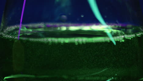 green fluorescent liquid in a glass container