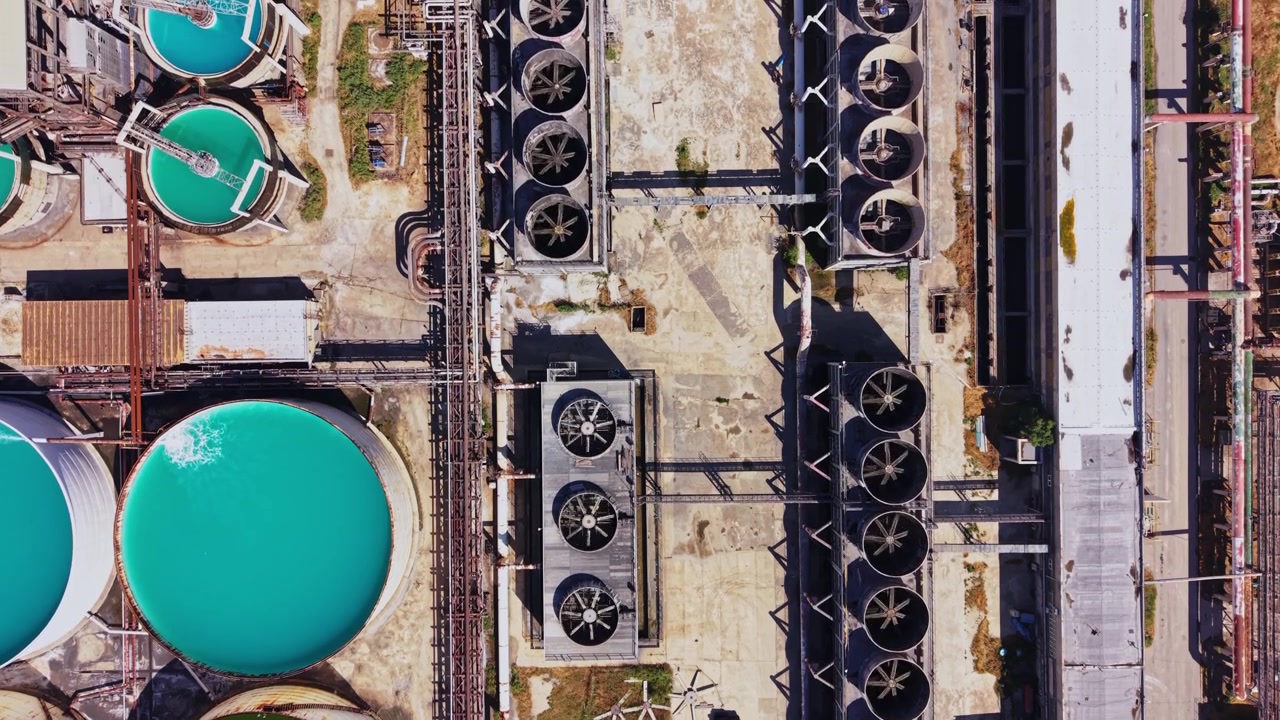 Industrial site with large tanks and cooling units in daytime