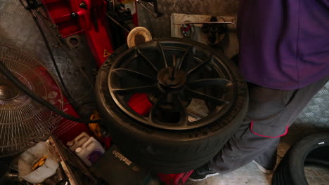 slow motion shot of a tyre fitter using a machine to put on a new tyre