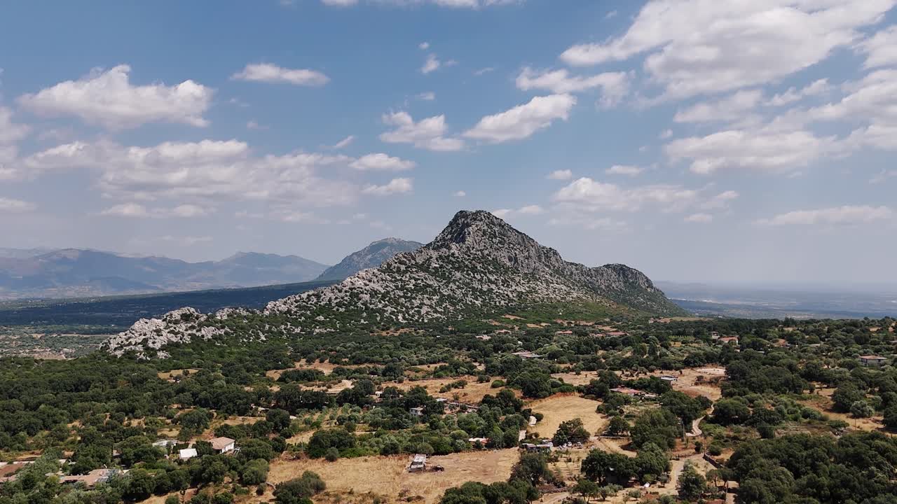 Sardinian mountain landscape under blue sky with scattered clouds