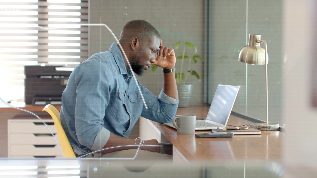 Vertical video: Reaching for mug, man in denim sipping, typing and analyzing laptop data at desk