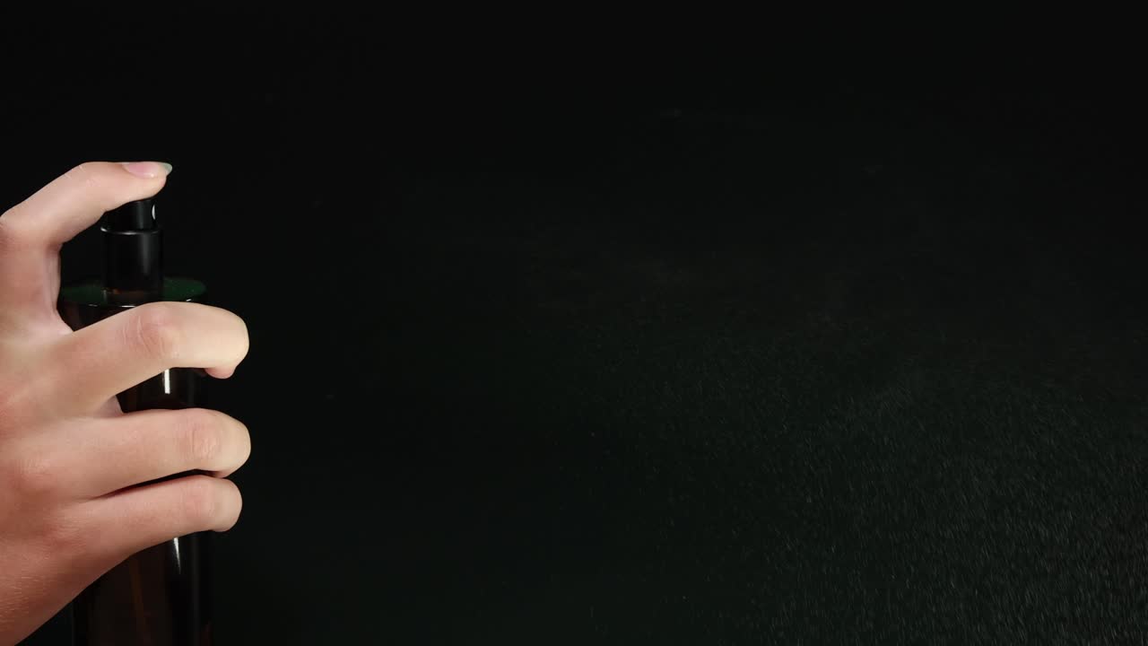 secuencia de un líquido rociado a mano de una botella oscura