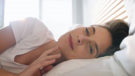 primer plano de una mujer despertando en su cama