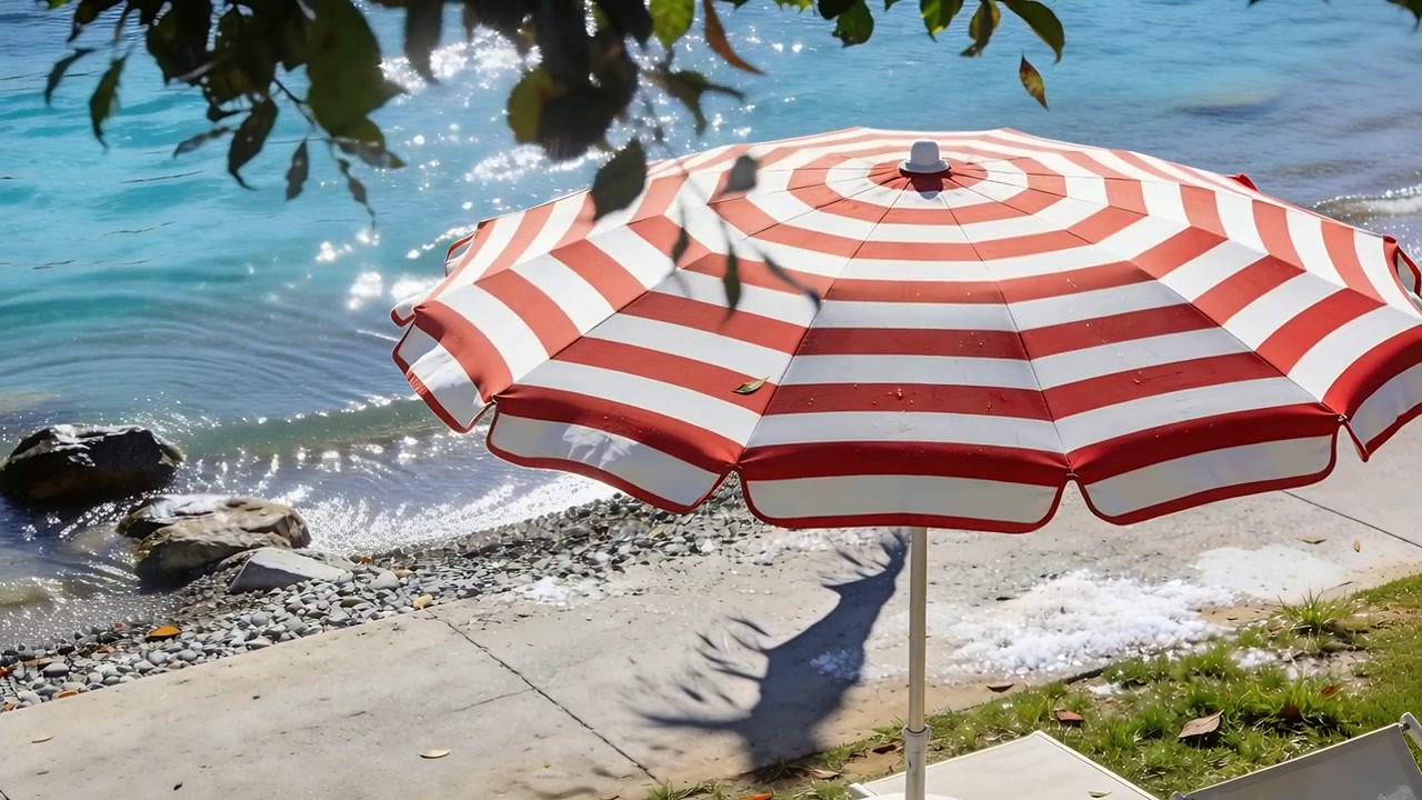 Brezza leggera che fa ondeggiare un ombrellone da spiaggia a strisce rosse e bianche sulla riva di ciottoli, con foglie che si spostano.