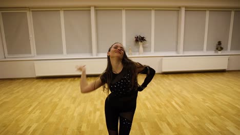 professional young female dancer moving effusively while practicing a choreography