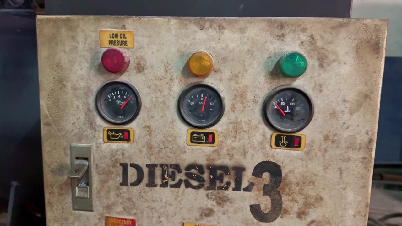 Electrical control panel on generator machine, industrial equipment with analog meters and indicators.