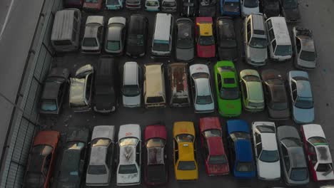 Car-dump-with-hundreds-of-cars-stacked-waiting-to-be-recycled-at-Kuala-lumpur,-aerial