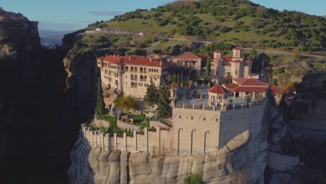 Monasterio-De-Meteora-De-4k-De-Varlaam,-Monasterio-En-Una-Bandeja-De-Montaña-A-La-Derecha,-Primer-Plano:-Dron-Aéreo,-Μετέωρα,-Ελληνικά-Meteora-Grecia,-Formación-De-Roca-Vertical,-Colores-De-Otoño,-Puesta-De-Sol,-Antigua-Grecia,-Cine