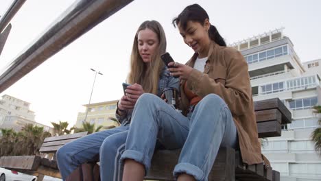 Low-angle-of-a-Caucasian-and-a-mixed-race-girl-using-their-phones